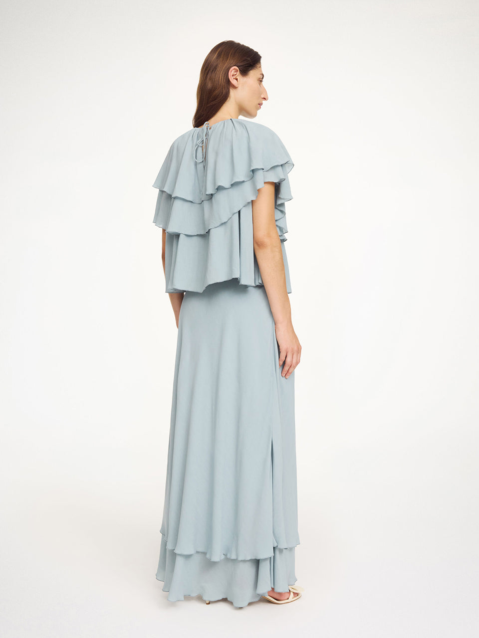 Luźny, błękitny top Nina Arona Blue By Malene Birger z okrągłym dekoltem i wiązaniem z tyłu. Składa się z kilku, półprzezroczystych warstw. Pierwsza falbana opada na ramiona, tworząc efekt 'rękawa skrzydełka'. Wykonany z wiskozy.&nbsp;

-Luźny, swobodny fason

-Bez rękawów&nbsp;

-Zamów w swoim standardowym rozmiarze&nbsp;