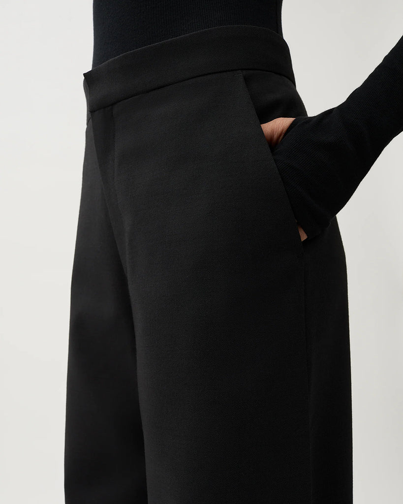 Czarne, garniturowe spodnie Nora Pike z wysokim stanem i kantem. Posiadają długą, rozszerzaną nogawkę. Mają elastyczny pas w talii i boczne kieszenie. Wykonane z lejącego, dzianinowego materiału zapewniającego komfort i swobodę ruchów. Idealne do eleganckich stylizacji.&nbsp;
