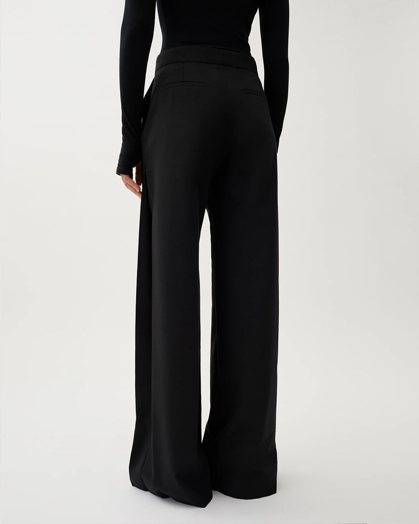 Czarne, garniturowe spodnie Nora Pike z wysokim stanem i kantem. Posiadają długą, rozszerzaną nogawkę. Mają elastyczny pas w talii i boczne kieszenie. Wykonane z lejącego, dzianinowego materiału zapewniającego komfort i swobodę ruchów. Idealne do eleganckich stylizacji.&nbsp;