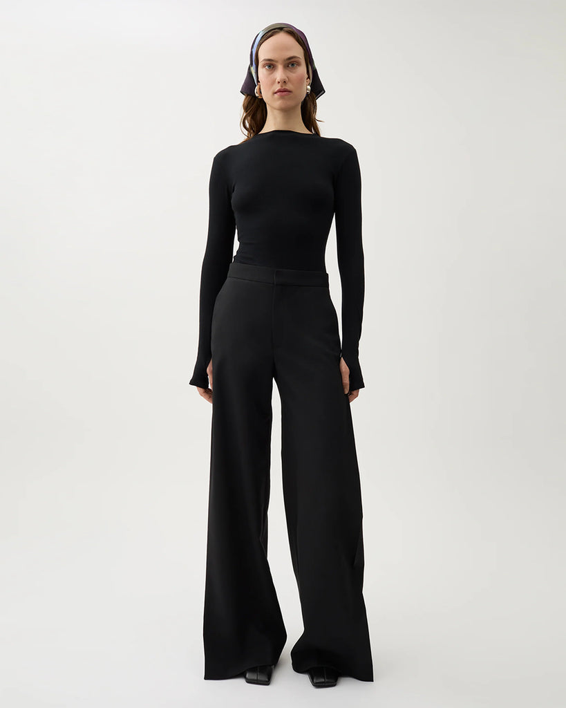 Czarne, garniturowe spodnie Nora Pike z wysokim stanem i kantem. Posiadają długą, rozszerzaną nogawkę. Mają elastyczny pas w talii i boczne kieszenie. Wykonane z lejącego, dzianinowego materiału zapewniającego komfort i swobodę ruchów. Idealne do eleganckich stylizacji.&nbsp;