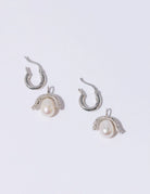 Efektowne, wiszące kolczyki PEARL OCTOPUSS.Y BABY PARIS SILVER z angielskim zapięciem. Złożone z grubego kółka i ściąganej zawieszki z dużą, naturalną perłą i połyskującym elementem wysadzanym drobnymi kryształami.

