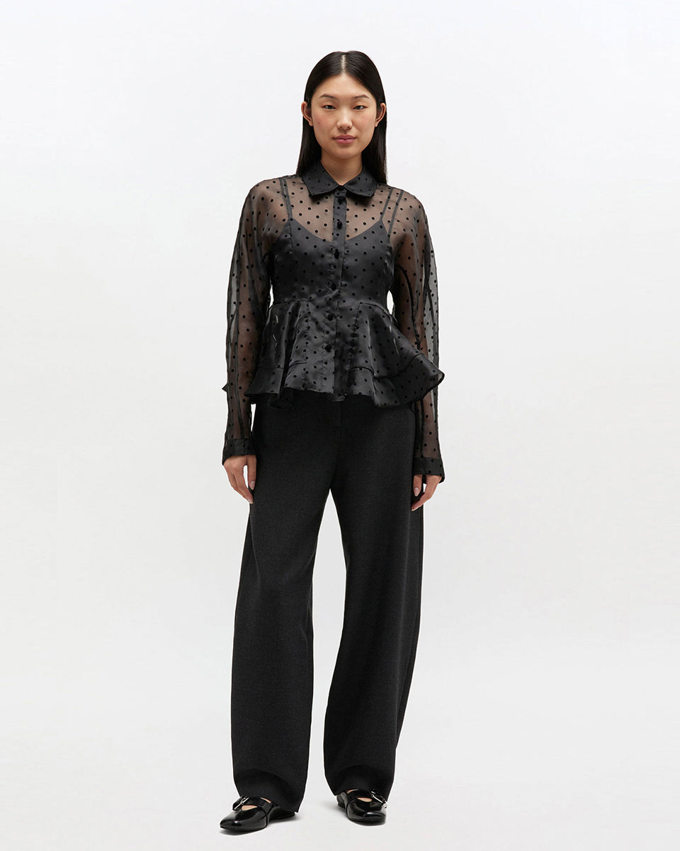 Efektowna koszula Organza Peplum Black marki GANNI z widocznym odcięciem w talii i mocno rozkloszowanym dołem. Posiada tradycyjny kołnierzyk i długie, proste rękawy zakończone mankietami. Zapinana z przodu na guziki. Prześwitujący materiał zdobiony jest klasycznym wzorem polka dots.&nbsp;

-Efekt baskinki

-Wzór polka dots

-Zamów w swoim standardowym rozmiarze