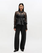 Efektowna koszula Organza Peplum Black marki GANNI z widocznym odcięciem w talii i mocno rozkloszowanym dołem. Posiada tradycyjny kołnierzyk i długie, proste rękawy zakończone mankietami. Zapinana z przodu na guziki. Prześwitujący materiał zdobiony jest klasycznym wzorem polka dots.&nbsp;

-Efekt baskinki

-Wzór polka dots

-Zamów w swoim standardowym rozmiarze
