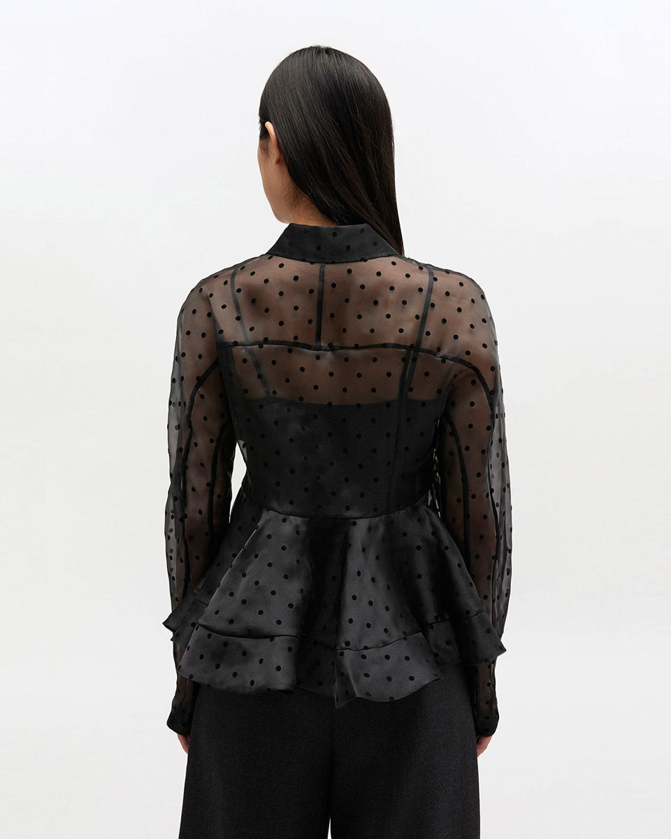 Efektowna koszula Organza Peplum Black marki GANNI z widocznym odcięciem w talii i mocno rozkloszowanym dołem. Posiada tradycyjny kołnierzyk i długie, proste rękawy zakończone mankietami. Zapinana z przodu na guziki. Prześwitujący materiał zdobiony jest klasycznym wzorem polka dots.&nbsp;

-Efekt baskinki

-Wzór polka dots

-Zamów w swoim standardowym rozmiarze