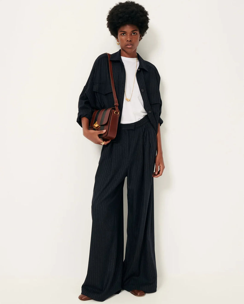 Luźne, materiałowe spodnie Orozco Navysand w paski, z wysokim stanem i przedłużeniem w talii z wewnętrznym zapięciem na haftki. Posiadają kieszenie ukośne i kieszenie z patką z tyłu, jedna zapinana na guzik. Noś je z ulubionym t-shirtem na codzień lub z koszulą, aby stworzyć bardziej elegancki look.