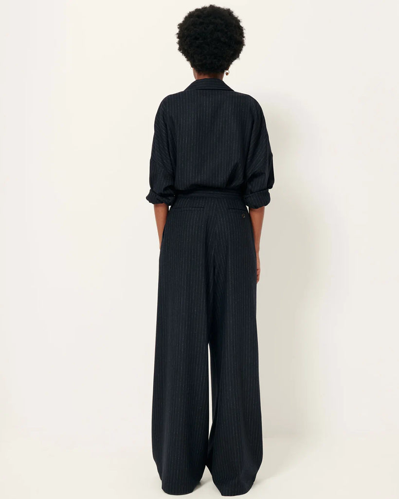 Luźne, materiałowe spodnie Orozco Navysand w paski, z wysokim stanem i przedłużeniem w talii z wewnętrznym zapięciem na haftki. Posiadają kieszenie ukośne i kieszenie z patką z tyłu, jedna zapinana na guzik. Noś je z ulubionym t-shirtem na codzień lub z koszulą, aby stworzyć bardziej elegancki look.