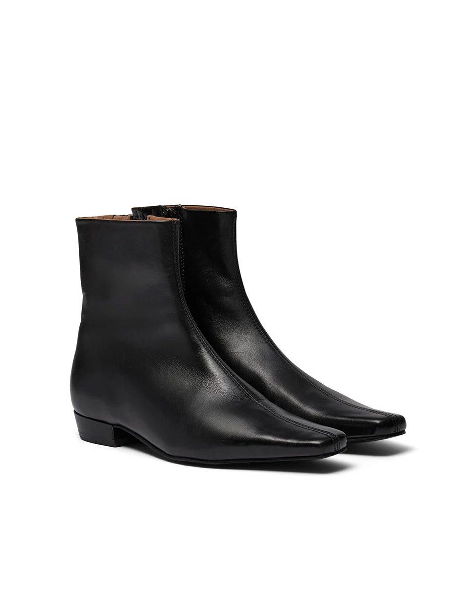 Eleganckie, czarne botki PAisla Black o minimalistycznym i nowoczesnym designie. Mają gładką cholewkę sięgającą ponad kostkę, z dyskretnym zamkiem błyskawicznym umieszczonym z boku. Ich najbardziej charakterystycznym elementem jest wyraźnie zarysowany, kwadratowy nosek, który nadaje całości geometrycznego, modnego charakteru. Mają niski, płaski obcas.&nbsp;

-Rozmiarówka jest standardowa. Zamów buty w rozmiarze, który zazwyczaj nosisz.