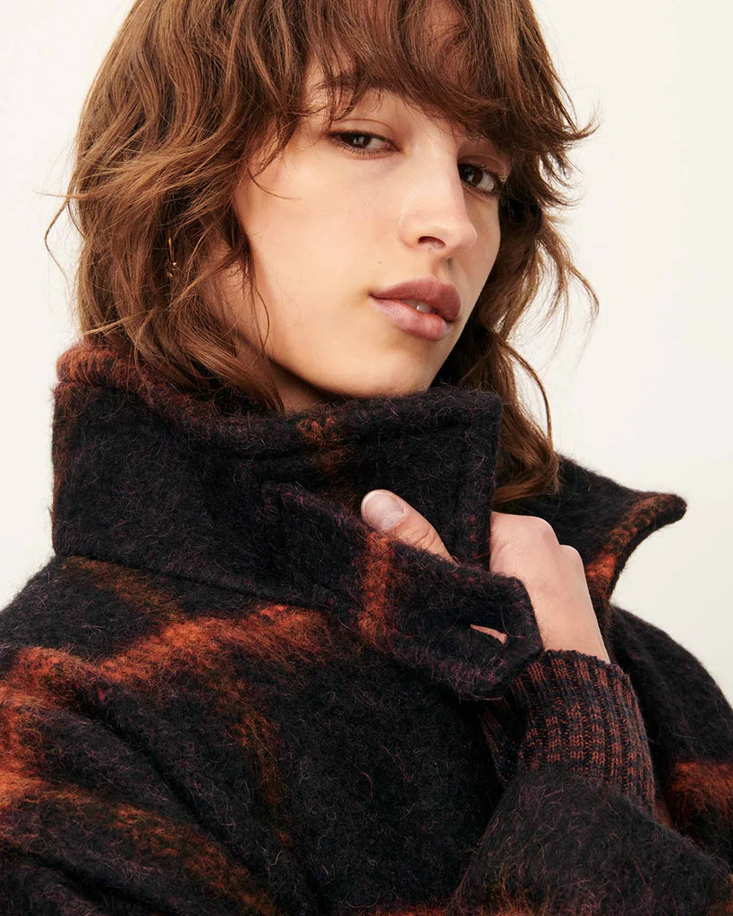 Krótki, ciepły płaszcz Paolino Navyrust w czerwoną kratę z wysokim kołnierzem i zakładkami przy otworach na ramiona. Zapinany na guziki. Z przodu posiada dwie kieszenie. Wykonany z miękkiej dzianiny z bawełną i wełną. Idealny jako dopełnienie codziennych, jesiennych stylizacji.&nbsp;