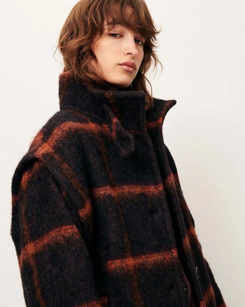 Krótki, ciepły płaszcz Paolino Navyrust w czerwoną kratę z wysokim kołnierzem i zakładkami przy otworach na ramiona. Zapinany na guziki. Z przodu posiada dwie kieszenie. Wykonany z miękkiej dzianiny z bawełną i wełną. Idealny jako dopełnienie codziennych, jesiennych stylizacji.&nbsp;