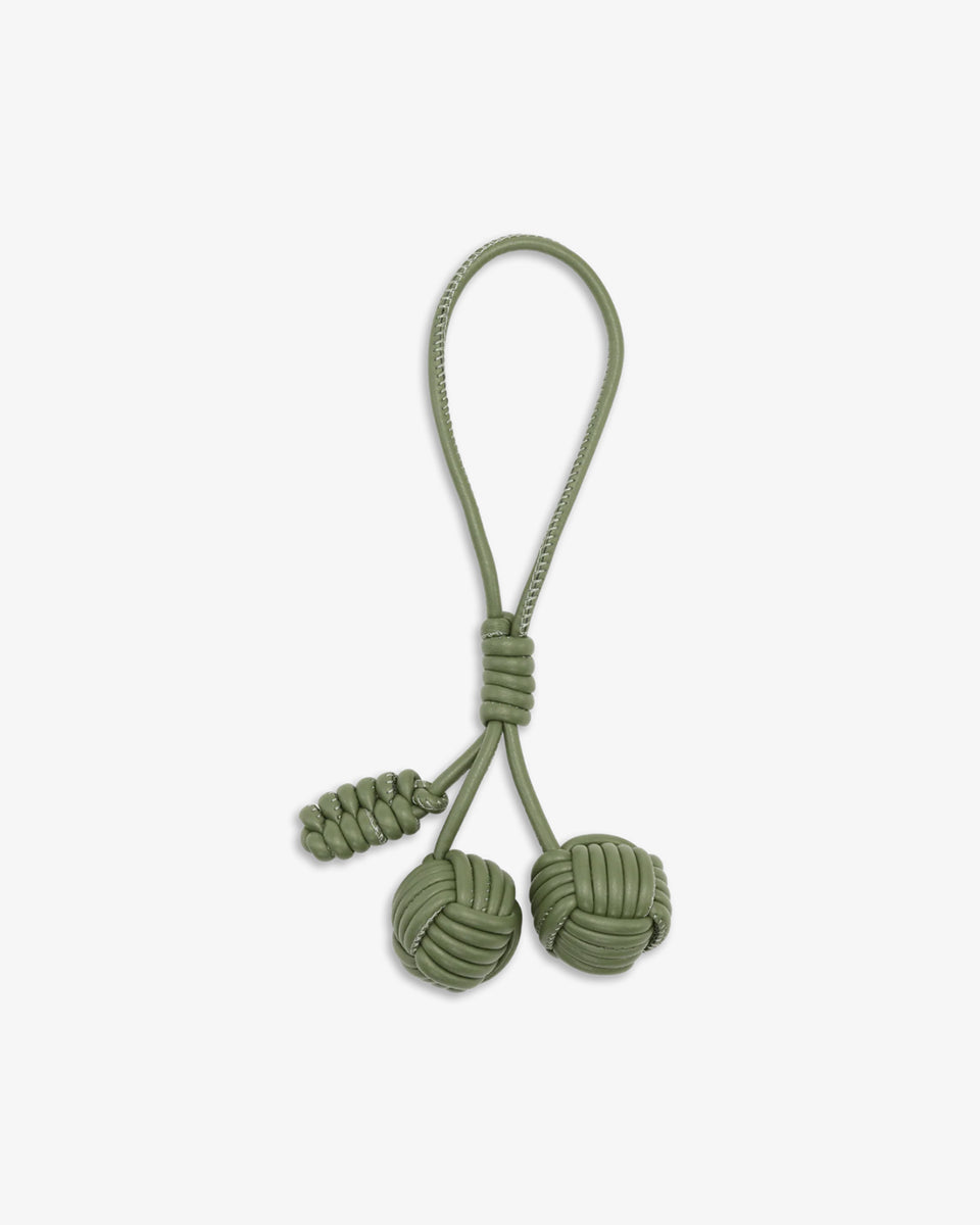 Uroczy breloczek Pine Cone SUI AVA składający się z plecionych kulek połączonych sznurkiem z pętelką, który bez z łatwością przymocujesz do torebki lub kluczy.