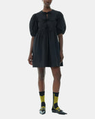 Luźna, czarna sukienka 9005 Poplin Mini Dress Black marki GANNI z okrągłym dekoltem i krótkimi, bufiastymi rękawami, które kończą się nad łokciem. Wiązana z przodu za pomocą sznurków. Odcięta wysoko w talii i rozkloszowana w dół. Wykonana z bawełny organicznej.

-Luźny fason

-100% bawełna organiczna

-Zamów w swoim standardowym rozmiarze