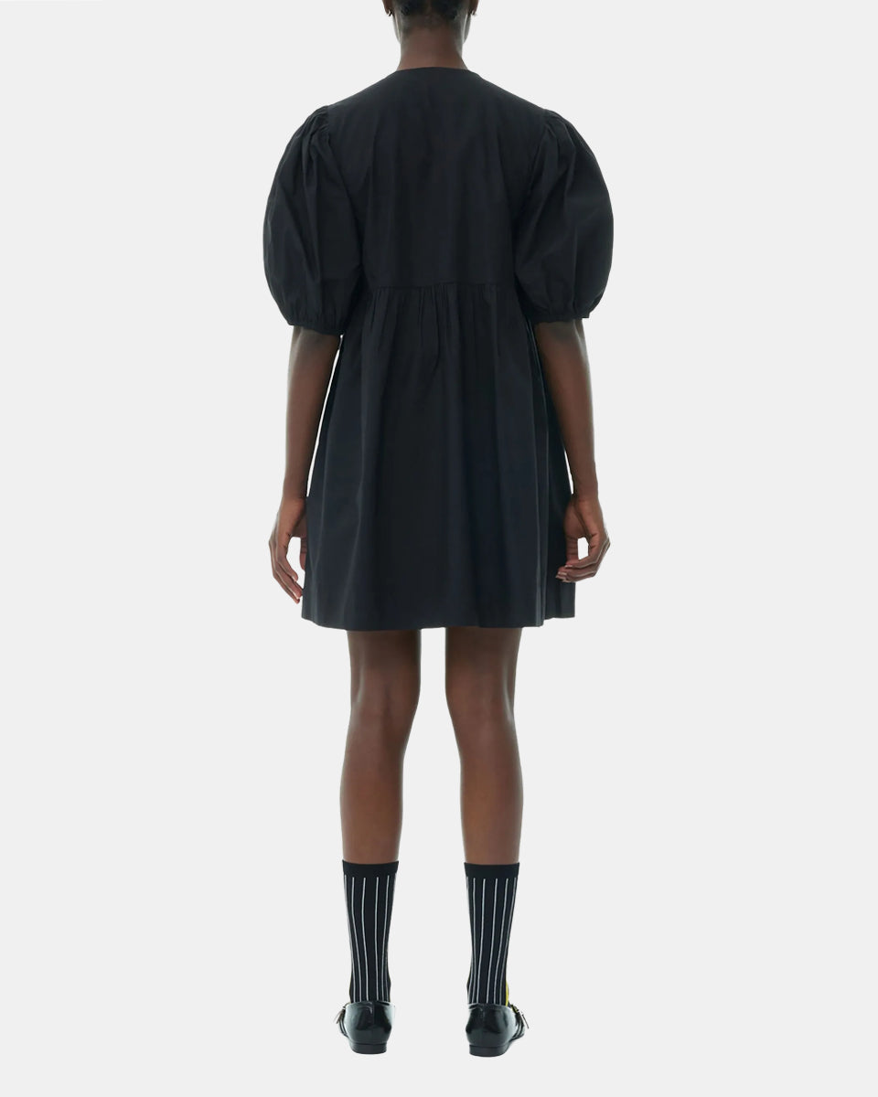 Luźna, czarna sukienka 9005 Poplin Mini Dress Black marki GANNI z okrągłym dekoltem i krótkimi, bufiastymi rękawami, które kończą się nad łokciem. Wiązana z przodu za pomocą sznurków. Odcięta wysoko w talii i rozkloszowana w dół. Wykonana z bawełny organicznej.

-Luźny fason

-100% bawełna organiczna

-Zamów w swoim standardowym rozmiarze