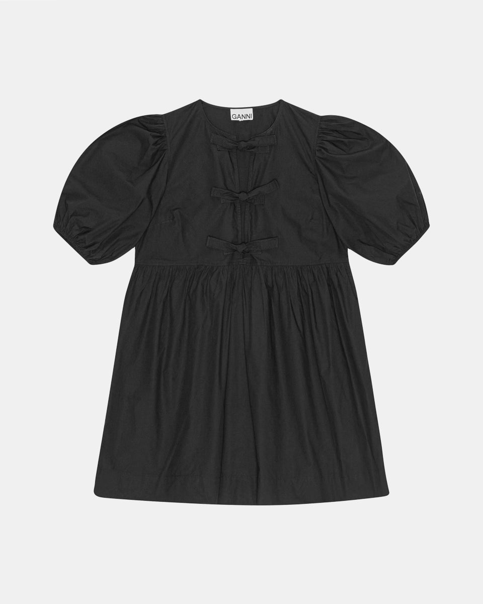 Luźna, czarna sukienka 9005 Poplin Mini Dress Black marki GANNI z okrągłym dekoltem i krótkimi, bufiastymi rękawami, które kończą się nad łokciem. Wiązana z przodu za pomocą sznurków. Odcięta wysoko w talii i rozkloszowana w dół. Wykonana z bawełny organicznej.

-Luźny fason

-100% bawełna organiczna

-Zamów w swoim standardowym rozmiarze