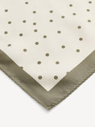 Klasyczna, piękna chusta Poulas Deep Lichen Green By Malene Birger w ponadczasowy wzór polka dots i kontrastową krawędzią. Wykonana z luksusowego jedwabiu. Zawiąż ją na szyi, nadgarstku lub rączce torebki.