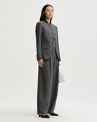 Eleganckie, ciemnoszare spodnie Povilanna By Malene Birger Dark Grey Melange wykonane z gładkiego, garniturowego materiału o prostym, formalnym kroju. Charakteryzują się one wysokim stanem oraz prostymi, lekko zaokrąglonymi nogawkami typu barrel. Z przodu każdej nogawki znajduje się wyraźnie zaprasowany w kant szew, który dodaje całości klasycznego charakteru.&nbsp;

-Nogawki o kroju "barrel"

-Wysoki stan

-Zaprasowane kanty