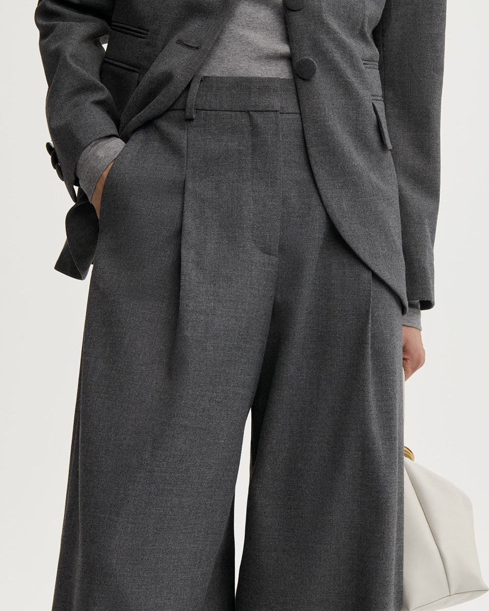 Eleganckie, ciemnoszare spodnie Povilanna By Malene Birger Dark Grey Melange wykonane z gładkiego, garniturowego materiału o prostym, formalnym kroju. Charakteryzują się one wysokim stanem oraz prostymi, lekko zaokrąglonymi nogawkami typu barrel. Z przodu każdej nogawki znajduje się wyraźnie zaprasowany w kant szew, który dodaje całości klasycznego charakteru.&nbsp;

-Nogawki o kroju "barrel"

-Wysoki stan

-Zaprasowane kanty