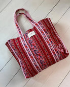 Duża torba typu shopper Pricilla Lavender Bloom SISSEL EDELBO z ręcznie wykonanym, kwiatowym printem i haftem. Wewnątrz posiada płócienną podszewkę i niewielką kieszonkę. Idealna na plażę, weekendowy wyjazd czy zakupy na targu.&nbsp;