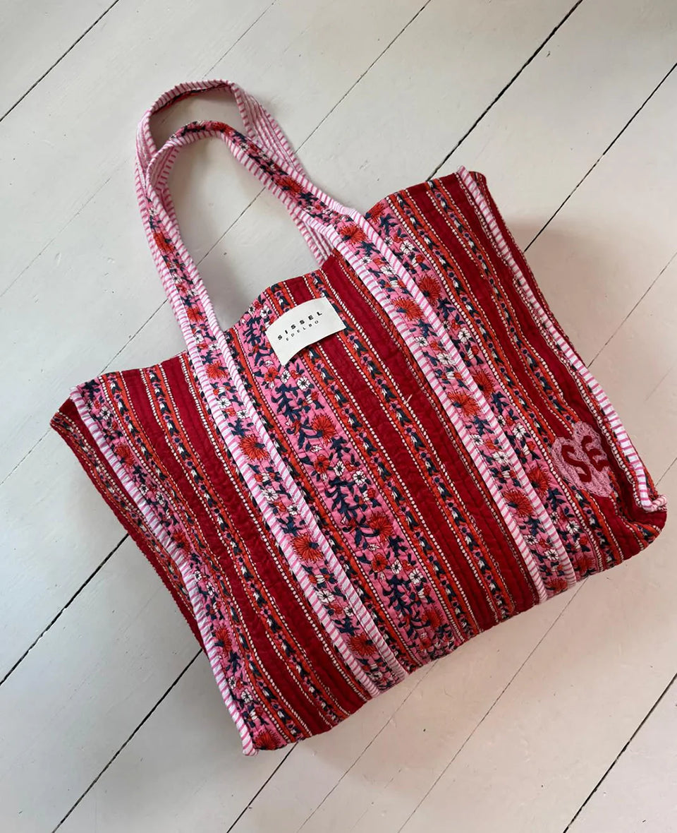 Duża torba typu shopper Pricilla Lavender Bloom SISSEL EDELBO z ręcznie wykonanym, kwiatowym printem i haftem. Wewnątrz posiada płócienną podszewkę i niewielką kieszonkę. Idealna na plażę, weekendowy wyjazd czy zakupy na targu.&nbsp;