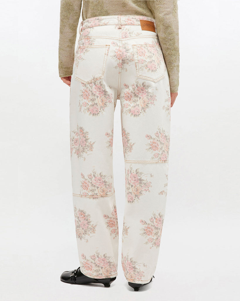 Luźne, bawełniane jeansy 1886 GANNI Print Denim ze średnim stanem i kwiatowym nadrukiem. Mają zapięcie na zamek błyskawiczny i guzik, pięć kieszeni, szlufki na pasek oraz naszywkę z logo marki. Wykonane w 100% z bawełny organicznej.&nbsp;