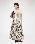 Długa, maxi spódnica Printed Long Skirt GANNI Egret wyróżnia się wyrazistym, zwierzęcym motywem tygrysich pasów. Ma trapezowy, lekko rozszerzany ku dołowi krój o swobodnej linii oraz obniżoną talię. Z tyłu posiada elastyczne marszczenie. Spódnica sięga do polowy łydki i świetnie prezentuje się w stylizacjach z prostymi t-shirtami oraz płaskimi butami. Wykonana z bawełny i elastanu.&nbsp;

-Zwierzęcy, wyrazisty print

-Długość maxi

-Bawełniana tkanina z elastanem