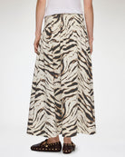 Długa, maxi spódnica Printed Long Skirt GANNI Egret wyróżnia się wyrazistym, zwierzęcym motywem tygrysich pasów. Ma trapezowy, lekko rozszerzany ku dołowi krój o swobodnej linii oraz obniżoną talię. Z tyłu posiada elastyczne marszczenie. Spódnica sięga do polowy łydki i świetnie prezentuje się w stylizacjach z prostymi t-shirtami oraz płaskimi butami. Wykonana z bawełny i elastanu.&nbsp;

-Zwierzęcy, wyrazisty print

-Długość maxi

-Bawełniana tkanina z elastanem