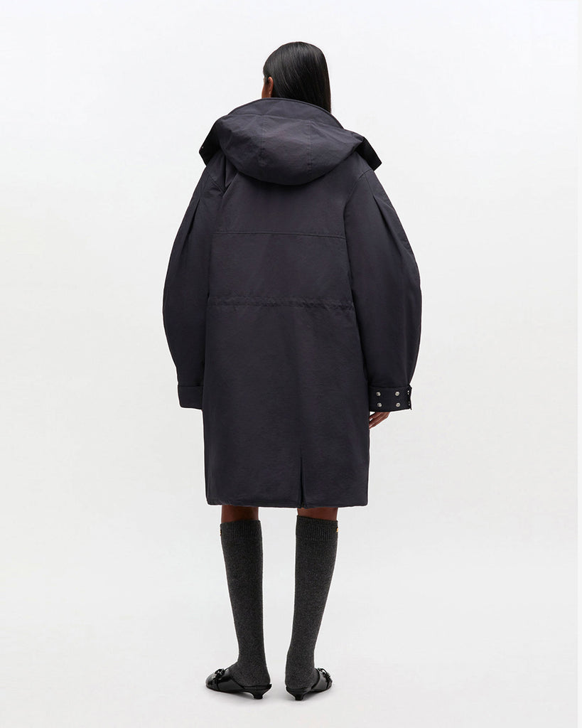 Luźny, prosty płaszcz typu parka 1012 Ganni Phantom o długości do kolan, z kapturem i mankietami. Posiada ściągacz w pasie i u dołu. Ma cztery kieszenie z przodu oraz kieszeń wewnętrzną. Nad lewą piersią znajduje się niewielka naszywka z logo marki.&nbsp;Zapinany za dwustronny zamek i srebrne, zatrzaskowe guziki.&nbsp;