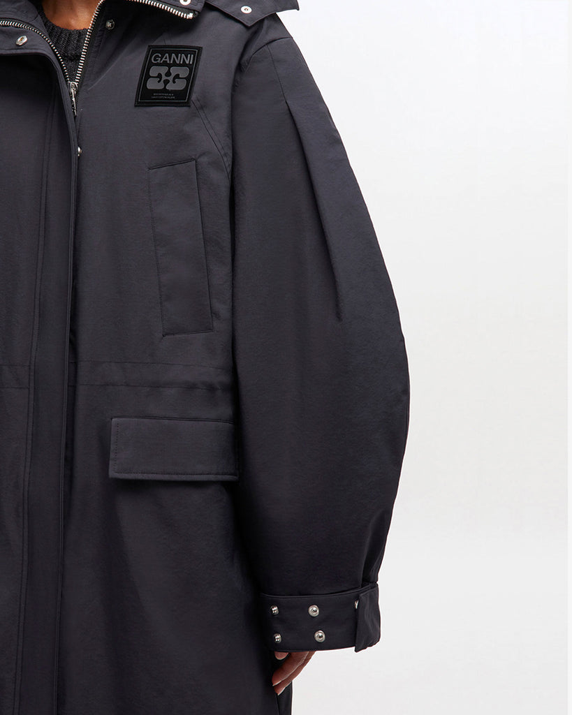 Luźny, prosty płaszcz typu parka 1012 Ganni Phantom o długości do kolan, z kapturem i mankietami. Posiada ściągacz w pasie i u dołu. Ma cztery kieszenie z przodu oraz kieszeń wewnętrzną. Nad lewą piersią znajduje się niewielka naszywka z logo marki.&nbsp;Zapinany za dwustronny zamek i srebrne, zatrzaskowe guziki.&nbsp;