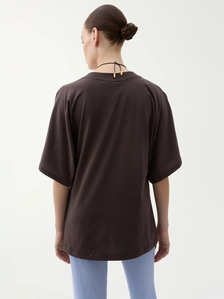 Luźny, brązowy t-shirt Pop Rodebjer z okrągłym dekoltem i luźnymi, krótkimi rękawami o długości do łokci. Koszula posiada prosty krój i długość za biodra. Wykonany z miękkiej, bawełnianej tkaniny.
