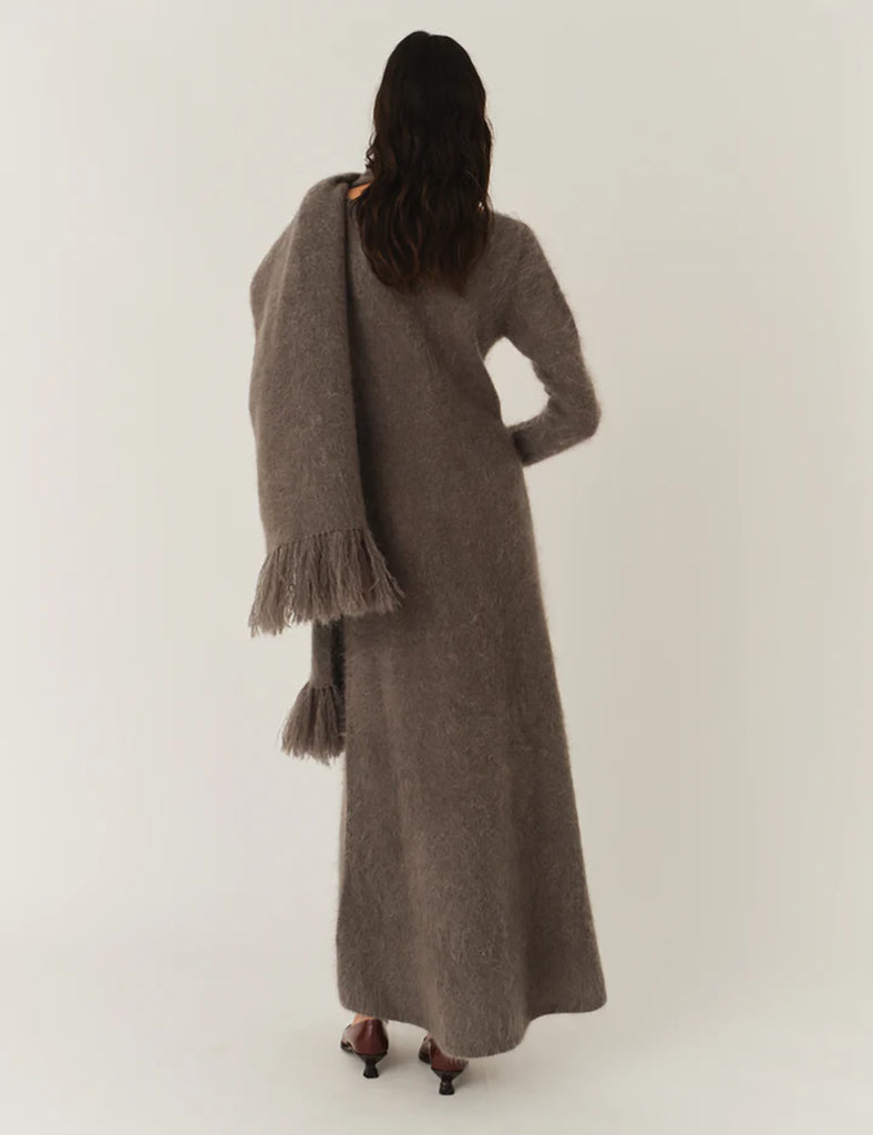 Bardzo długa, prosta sukienka Roma Grey Melange o długości do kostek. Jest delikatnie dopasowana do sylwetki, ale nie obcisła. Ma luźniejszy, swobodny charakter. Ma długie, wąskie rękawy oraz prosty dekolt. Wykonana z puszystej dzianiny z moheru. Zestaw ją ze szpilkami i delikatną biżuterią, aby uzyskać elegancki look lub z ciężkimi butami i noś ją na codzień.&nbsp;