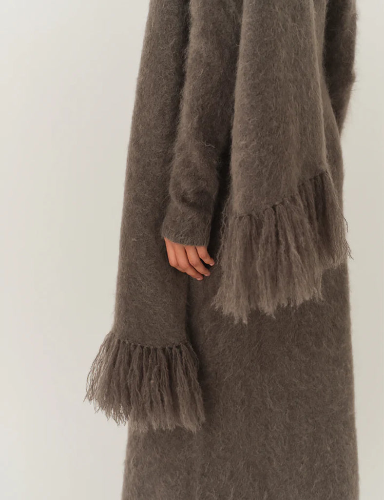 Bardzo długa, prosta sukienka Roma Grey Melange o długości do kostek. Jest delikatnie dopasowana do sylwetki, ale nie obcisła. Ma luźniejszy, swobodny charakter. Ma długie, wąskie rękawy oraz prosty dekolt. Wykonana z puszystej dzianiny z moheru. Zestaw ją ze szpilkami i delikatną biżuterią, aby uzyskać elegancki look lub z ciężkimi butami i noś ją na codzień.&nbsp;