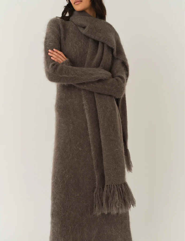 Bardzo długa, prosta sukienka Roma Grey Melange o długości do kostek. Jest delikatnie dopasowana do sylwetki, ale nie obcisła. Ma luźniejszy, swobodny charakter. Ma długie, wąskie rękawy oraz prosty dekolt. Wykonana z puszystej dzianiny z moheru. Zestaw ją ze szpilkami i delikatną biżuterią, aby uzyskać elegancki look lub z ciężkimi butami i noś ją na codzień.&nbsp;