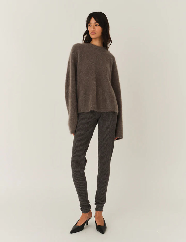 Bardzo miękki, oversizowy sweter Roma Grey Melange z okrągłym dekoltem i długimi, luźnymi rękawami. Wykonany z dzianiny z moherem. Idealny do spodni i spódnic z wysokim stanem.