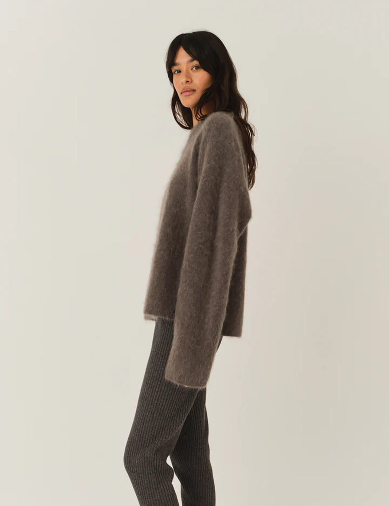 Bardzo miękki, oversizowy sweter Roma Grey Melange z okrągłym dekoltem i długimi, luźnymi rękawami. Wykonany z dzianiny z moherem. Idealny do spodni i spódnic z wysokim stanem.
