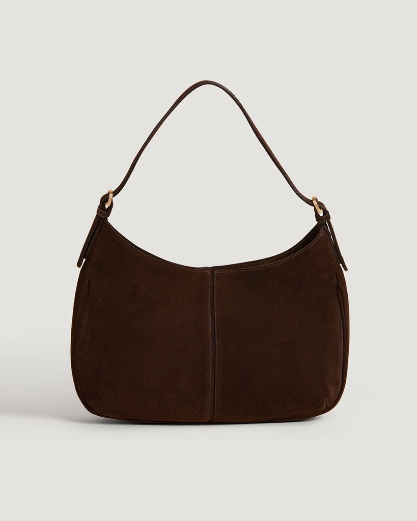 Zamszowa, brązowa torebka o średniej wielkości Big Rouje z zaokrąglonymi kątami i krótkim, regulowanym paskiem do wygodnego trzymania w dłoni i zawieszenia na ramieniu. Zapinana za pomocą magnesu. Wewnątrz obszyta różową, satynową podszewką.