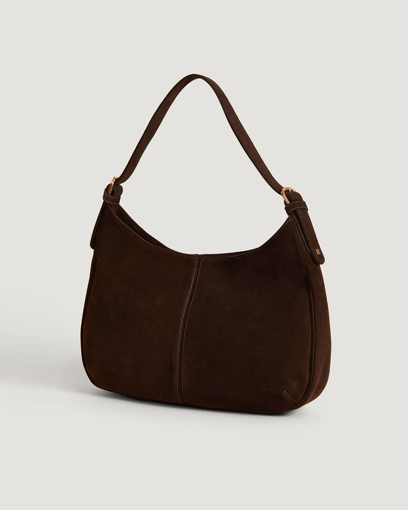 Zamszowa, brązowa torebka o średniej wielkości Big Rouje z zaokrąglonymi kątami i krótkim, regulowanym paskiem do wygodnego trzymania w dłoni i zawieszenia na ramieniu. Zapinana za pomocą magnesu. Wewnątrz obszyta różową, satynową podszewką.