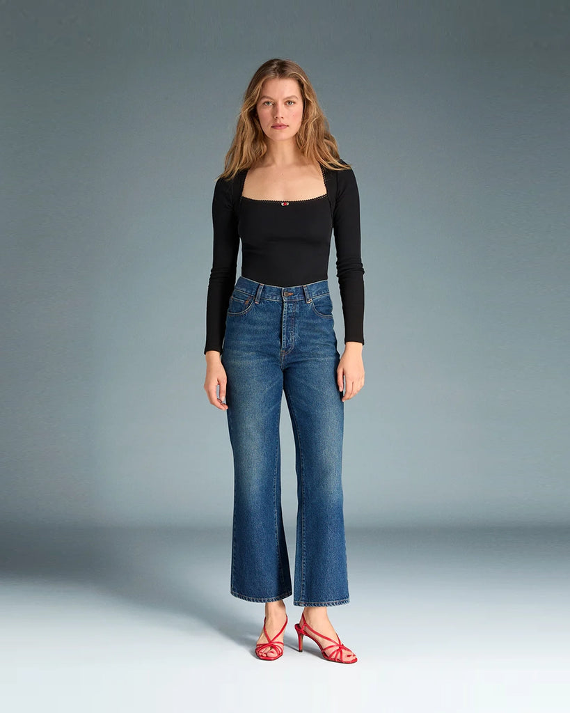 Granatowe jeansy o kobiecym fasonie Concorde Rouje z wysokim stanem i rozszerzaną u dołu, skróconą nogawką. Dopasowane w biodrach i udach. Posiadają pięć kieszeni. Nad lewą kieszenią znajduje się niewielka, haftowana litera R. Zapinane na zamek błyskawiczny i guzik. To model pięknie podkreślający sylwetkę. 