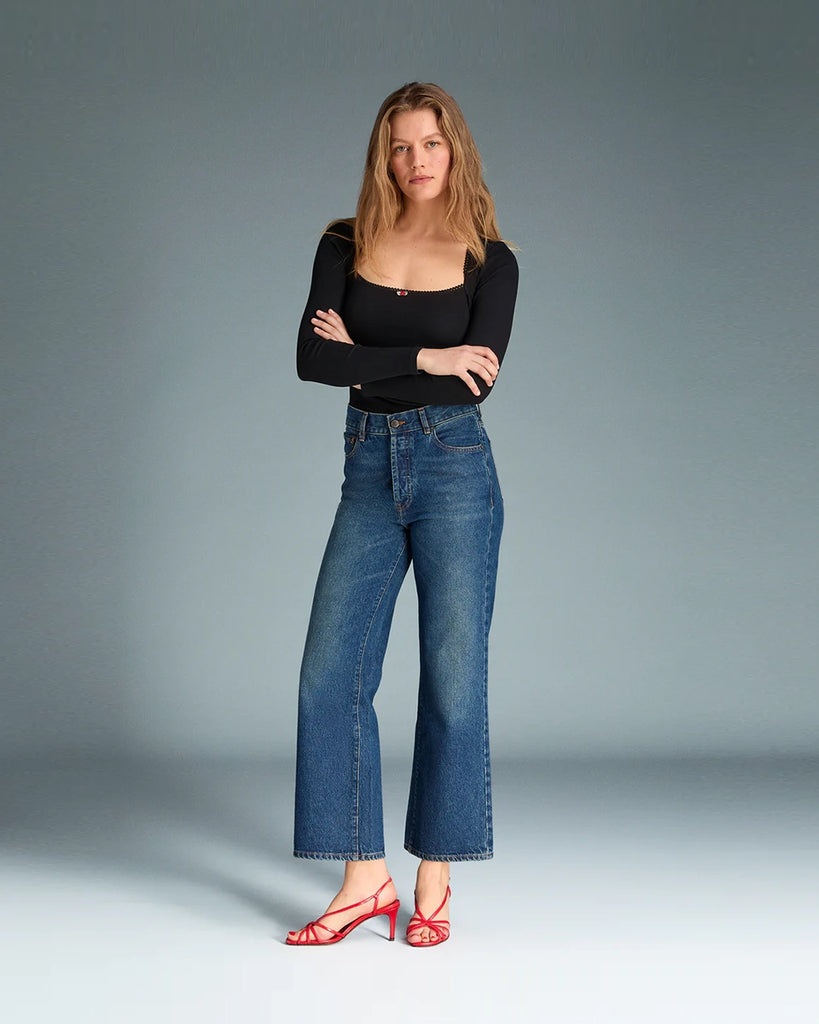 Granatowe jeansy o kobiecym fasonie Concorde Rouje z wysokim stanem i rozszerzaną u dołu, skróconą nogawką. Dopasowane w biodrach i udach. Posiadają pięć kieszeni. Nad lewą kieszenią znajduje się niewielka, haftowana litera R. Zapinane na zamek błyskawiczny i guzik. To model pięknie podkreślający sylwetkę. 