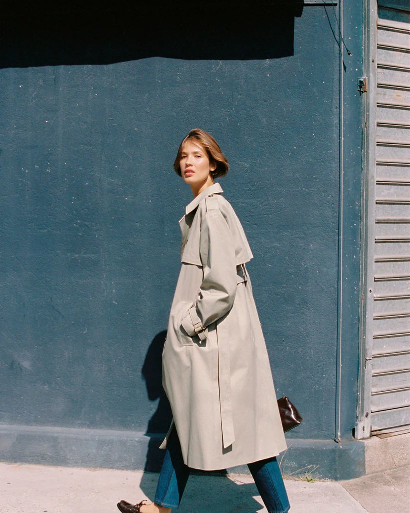 Klasyczny luźny, dwurzędowy prochowiec Ezra Rouje wiązany w talii za pomocą wyciąganego, szerokiego paska. Posiada kołnierzyk, pagony na ramionach i luźne rękawy z paskami przy mankietach. Z tyłu u dołu ma rozcięcie. Płaszcz posiada dwie, boczne kieszenie i podszewkę we wzór w panterę. Jest zapinany na guziki imitujące poroże.