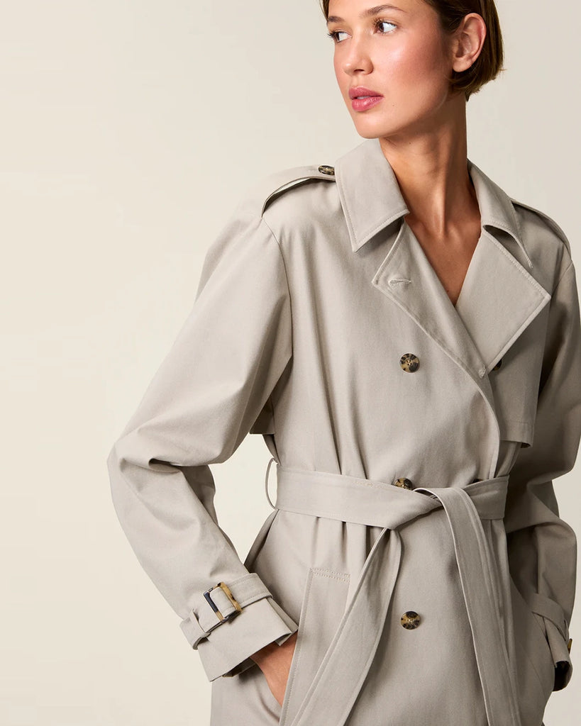 Klasyczny luźny, dwurzędowy prochowiec Ezra Rouje wiązany w talii za pomocą wyciąganego, szerokiego paska. Posiada kołnierzyk, pagony na ramionach i luźne rękawy z paskami przy mankietach. Z tyłu u dołu ma rozcięcie. Płaszcz posiada dwie, boczne kieszenie i podszewkę we wzór w panterę. Jest zapinany na guziki imitujące poroże.