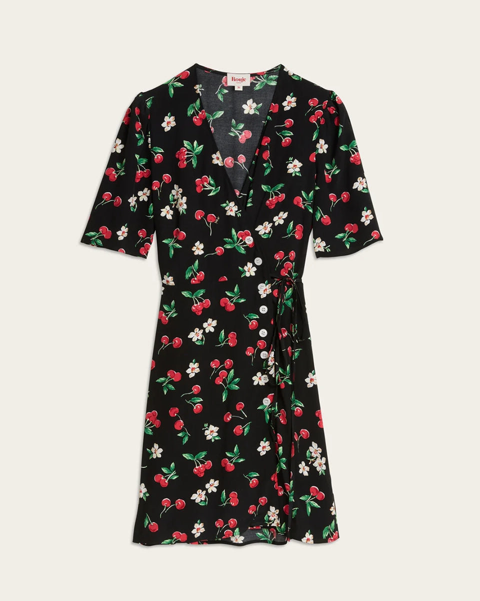 Zwiewna, kopertowa sukienka mini Gabinette Rouje w piękny print z motywem wiśni. Posiada dekolt w kształcie litery V i krótki, lekko bufiasty rękaw. Z boku zapinana na pięć guzików z masy perłowej. Wiązana i przylegająca w talii. Sukienka ma długość do połowy uda. Wykonana z wiskozy. Idealna w połączeniu z klapkami na niewielkim obcasie lub balerinami.&nbsp;