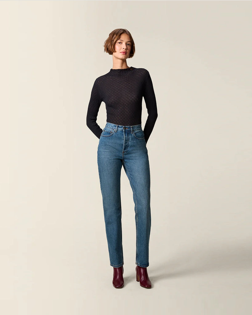 Cienki, ażurowy, dzianinowy longsleeve Galina Rouje o dopasowanym fasonie. Posiada wysoki dekolt. Przy szyi i na końcu rękawów wykończony falbanką. Idealny do spodnie z wysokim stanem.