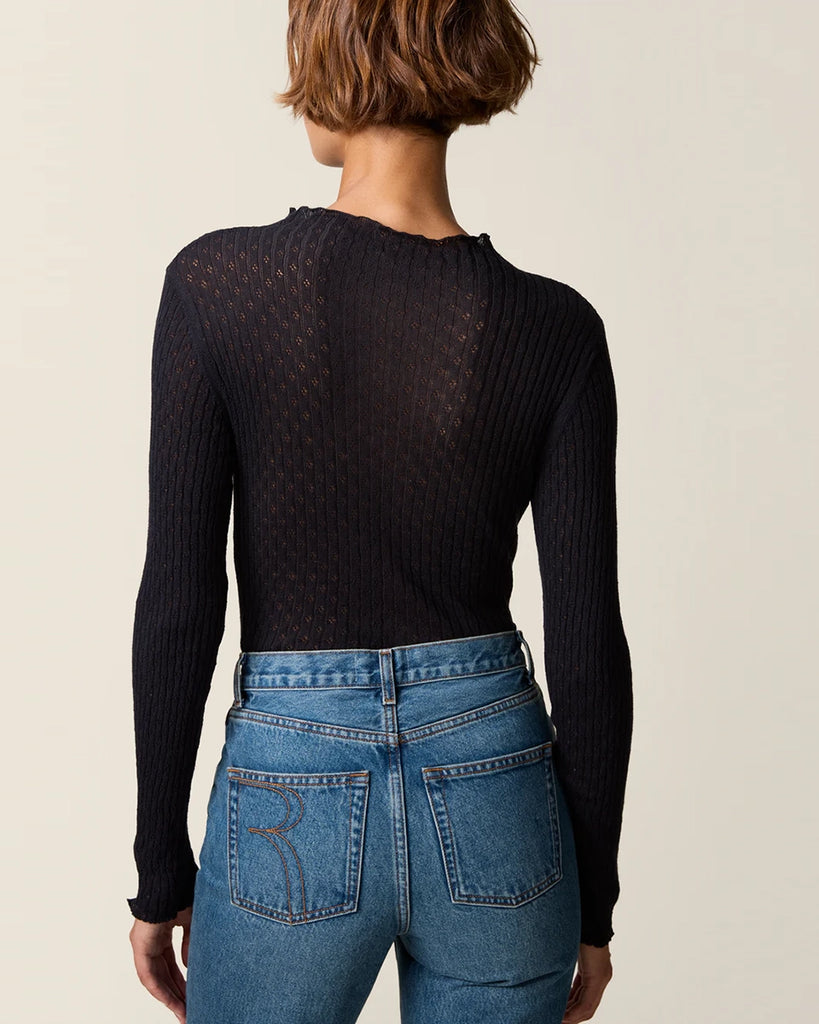 Cienki, ażurowy, dzianinowy longsleeve Galina Rouje o dopasowanym fasonie. Posiada wysoki dekolt. Przy szyi i na końcu rękawów wykończony falbanką. Idealny do spodnie z wysokim stanem.