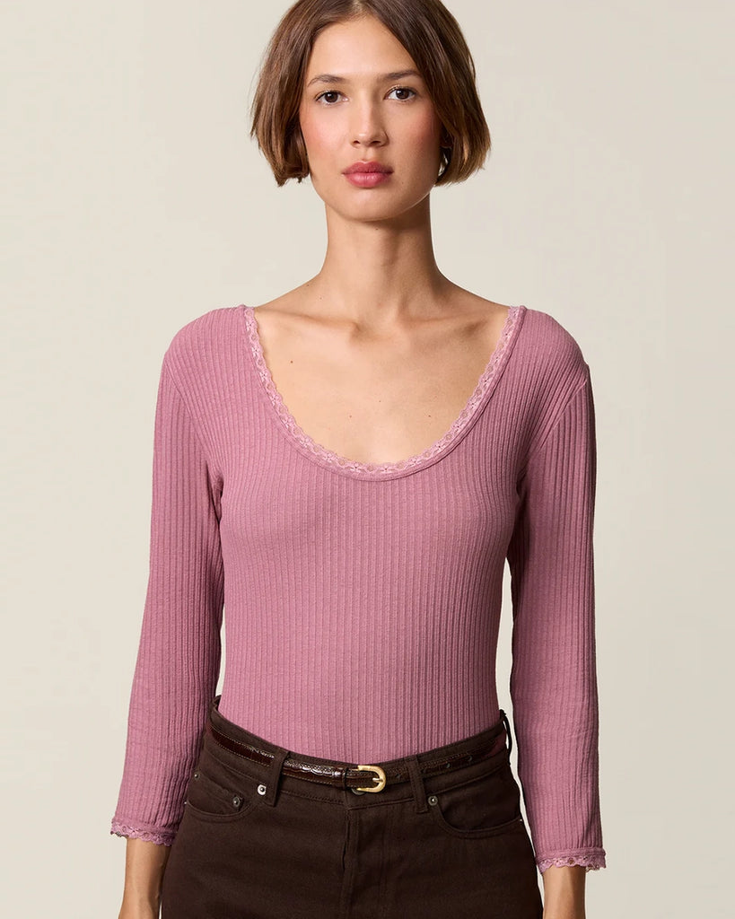 Dopasowana, prosta bluzka Gio Rouje z głębokim, okrągłym dekoltem obszytym uroczą koronką. Posiada wąskie rękawy o długości przed nadgarstki wykończone koronką. Wykonana z cienkiej tkaniny z prążkowaną fakturą.