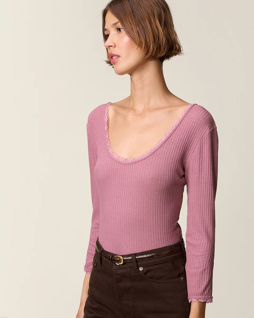 Dopasowana, prosta bluzka Gio Rouje z głębokim, okrągłym dekoltem obszytym uroczą koronką. Posiada wąskie rękawy o długości przed nadgarstki wykończone koronką. Wykonana z cienkiej tkaniny z prążkowaną fakturą.