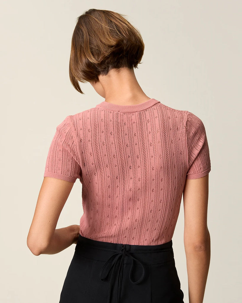 Cienka, dzianinowa bluzka Hugo Rouje z okrągłym dekoltem i krótkim rękawem. Wykonana z ażurowej, lekko prześwitującej tkaniny z wiskozą. U dołu wykończona falbanką.