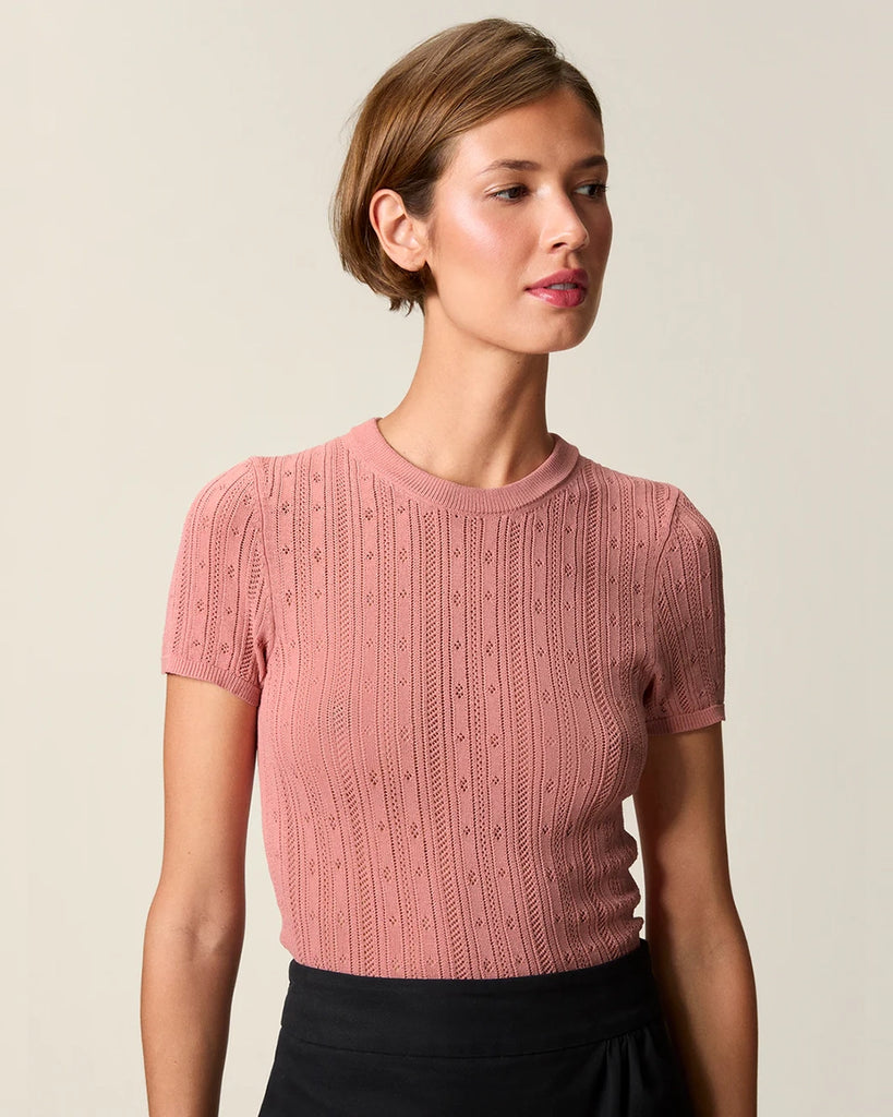 Cienka, dzianinowa bluzka Hugo Rouje z okrągłym dekoltem i krótkim rękawem. Wykonana z ażurowej, lekko prześwitującej tkaniny z wiskozą. U dołu wykończona falbanką.