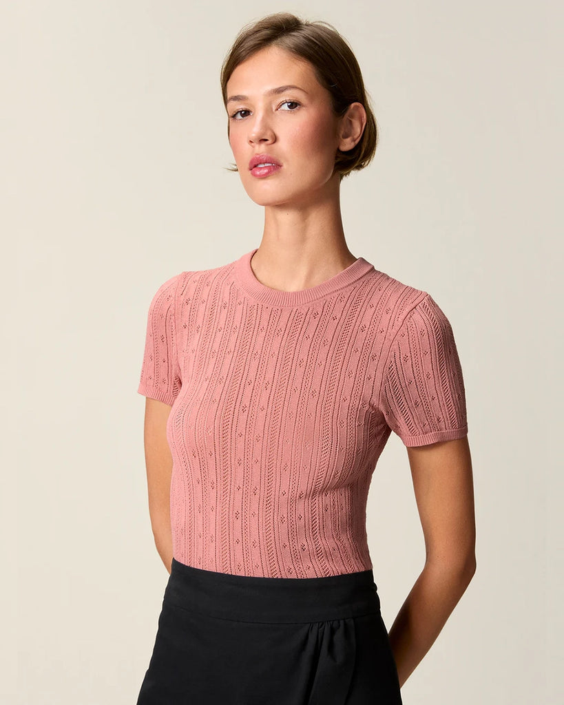 Cienka, dzianinowa bluzka Hugo Rouje z okrągłym dekoltem i krótkim rękawem. Wykonana z ażurowej, lekko prześwitującej tkaniny z wiskozą. U dołu wykończona falbanką.