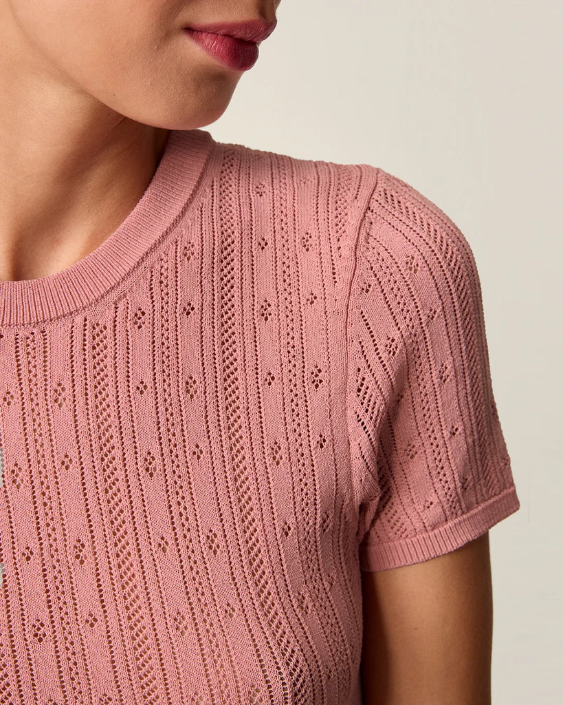 Cienka, dzianinowa bluzka Hugo Rouje z okrągłym dekoltem i krótkim rękawem. Wykonana z ażurowej, lekko prześwitującej tkaniny z wiskozą. U dołu wykończona falbanką.