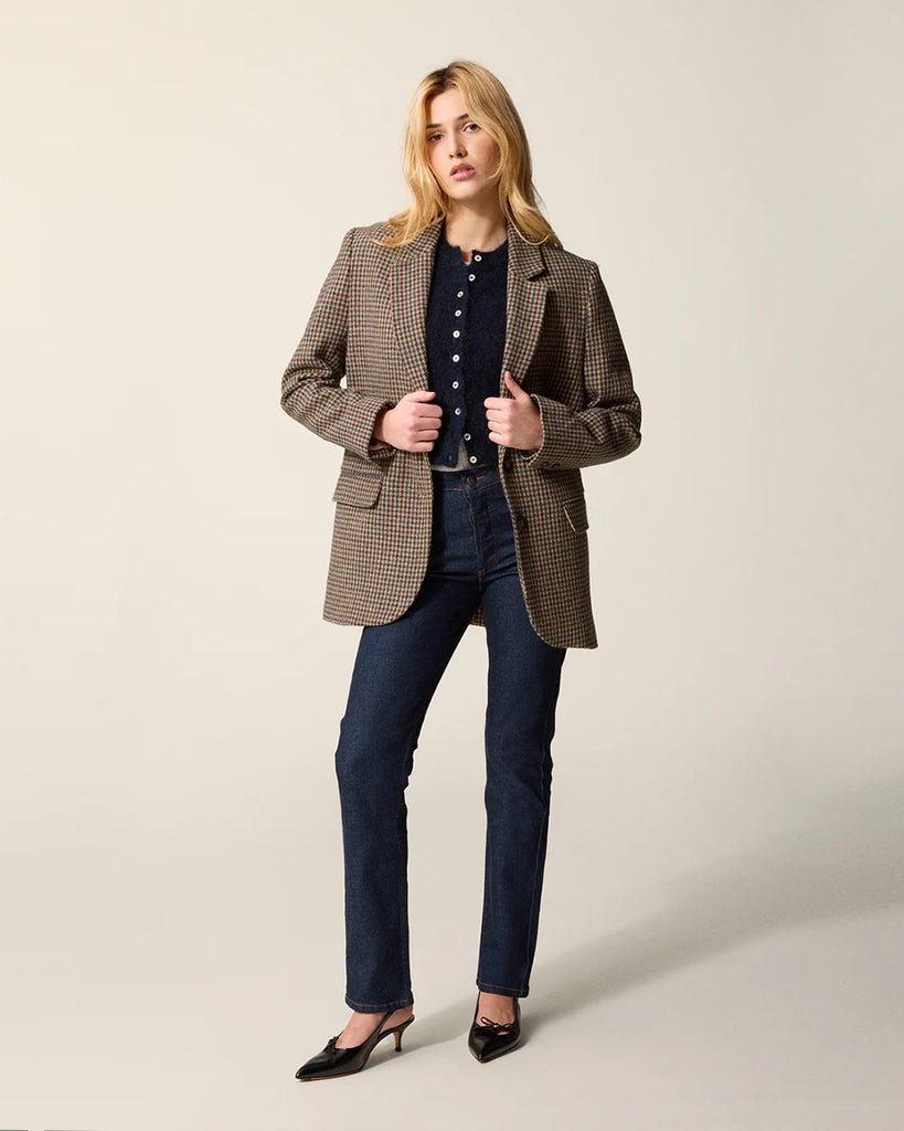 Klasyczna, jednorzędowa, wełniana marynarka w pepitkę Jacques Rouje o prostym kroju i długości za biodra. Zapinana na dwa guziki imitujące poroże. Marynarka ma klapy i trójkątny dekolt. Posiada dwie, przednie kieszenie z klapkami, niewielkie rozcięcie z tyłu i podszewkę