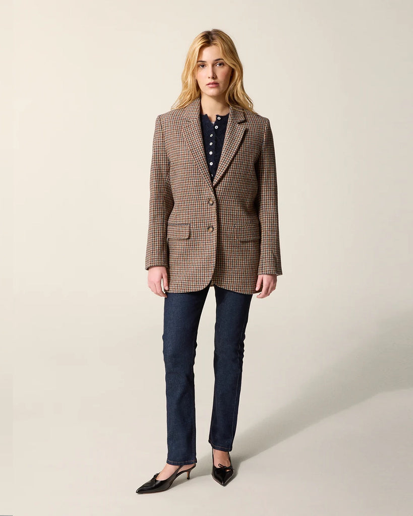 Klasyczna, jednorzędowa, wełniana marynarka w pepitkę Jacques Rouje o prostym kroju i długości za biodra. Zapinana na dwa guziki imitujące poroże. Marynarka ma klapy i trójkątny dekolt. Posiada dwie, przednie kieszenie z klapkami, niewielkie rozcięcie z tyłu i podszewkę